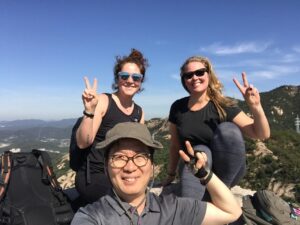 Foreigner and Korean posing in pine forest during spring trip